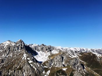 Scenic view of snow mountains against clear blue sky