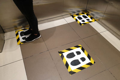 Low section of woman standing on tiled floor