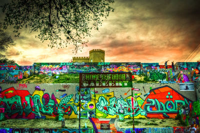 Graffiti on wall against cloudy sky