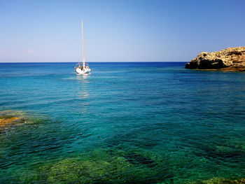 Sailboat sailing in sea against sky