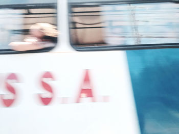 Blurred motion of person seen through window in swimming pool