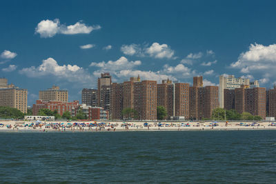 Scenic view of sea by buildings against sky