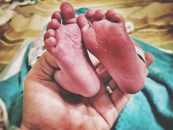 Cropped image of hand holding newborn baby feet