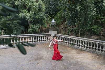 Female dancer dancing near in front of trees