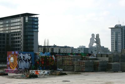 Graffiti on modern buildings in city against sky