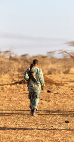 Rear view of a person walking on field