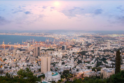 High angle view of city buildings against cloudy sky