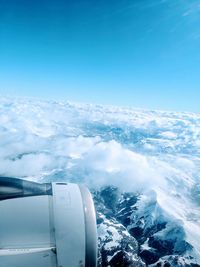 Aerial view of snowcapped mountain against blue sky