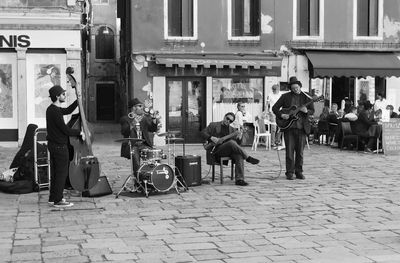 Street musician performing against building in city