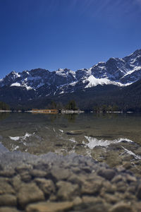 Scenic view of lake and snowcapped mountains against sky