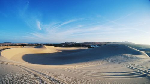 Panoramic view of desert against blue sky