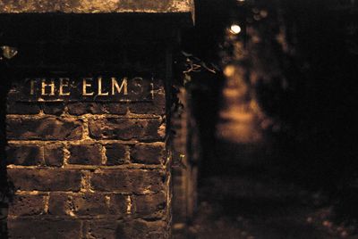 Close-up of illuminated text on wall at night