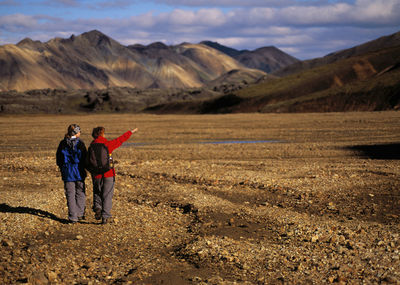 Rear view of men standing on landscape