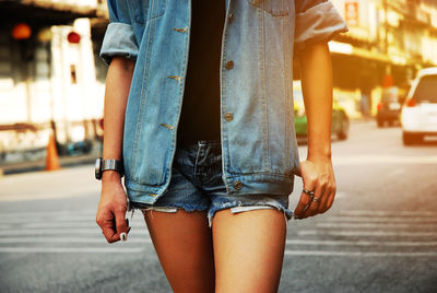 Midsection of woman standing on street