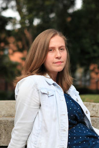 Portrait of young woman sitting outdoors