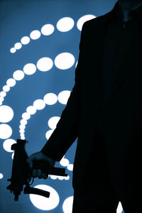 Close-up of man holding illuminated lighting equipment at night