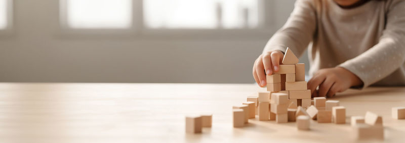 Midsection of woman with toy blocks on table