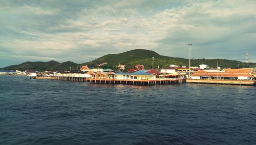 Scenic view of sea by buildings against sky