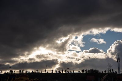 Panoramic view of silhouette buildings in city against storm clouds