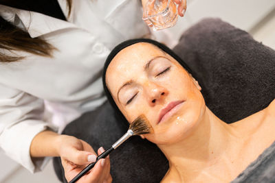 Close-up of woman applying nail