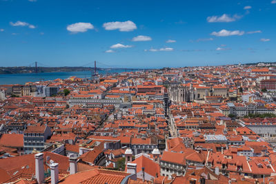 Lisbon historic city centre red roof houses tagus river against cloudy sky