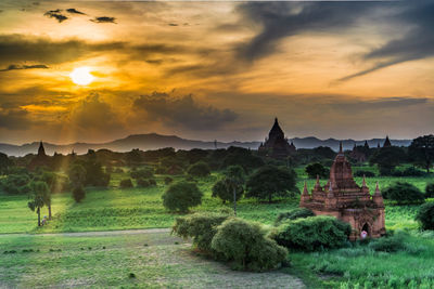 Panoramic view of temple by building against sky during sunset