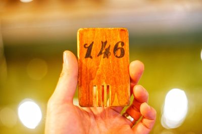 Cropped hand holding toy blocks on table