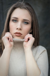 Close-up portrait of beautiful young woman wearing sweater at home