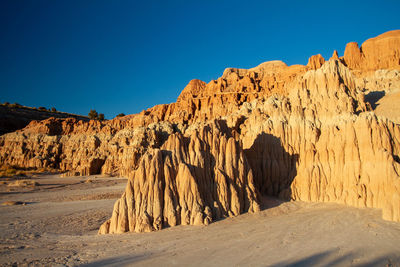 Rock formations in desert against clear blue sky