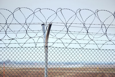 Low angle view of chainlink fence against sky