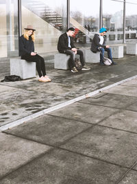 People on seat using phones at roadside