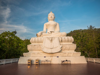 Statue of buddha against cloudy sky