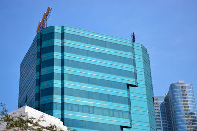 Low angle view of modern building against clear blue sky