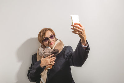 Young woman using mobile phone against white background