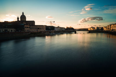 View of buildings at waterfront against cloudy sky