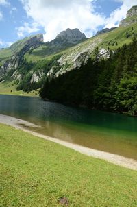 Scenic view of lake by mountains against sky