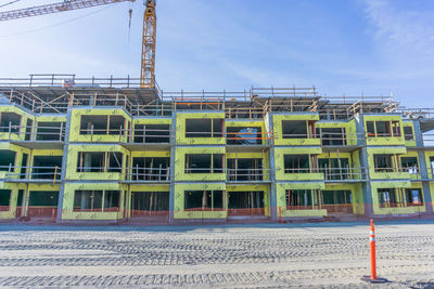 Construction site on beach against sky in city