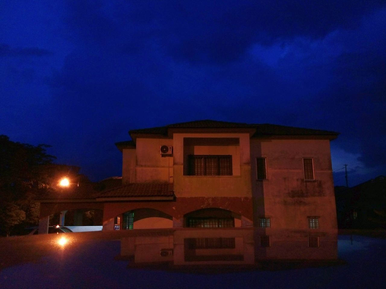 building exterior, architecture, illuminated, built structure, night, sky, street light, dusk, cloud - sky, low angle view, street, lighting equipment, blue, outdoors, cloud, house, residential structure, facade, building, no people