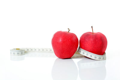 Close-up of red fruits over white background