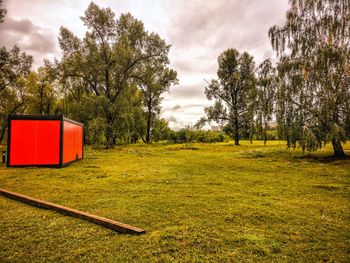 Red hut on grass against sky