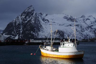 Sailboat on snowcapped mountains against sky