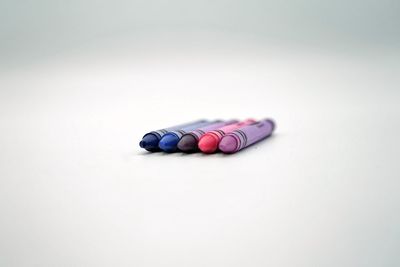 Close-up of colored pencils over white background