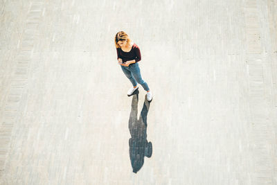 Portrait of young woman standing against wall