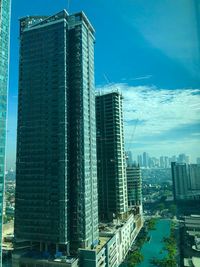 Modern buildings in city against blue sky