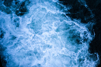 Beautiful foamy sea. water flowing from the open sluice gates of dam. the blue sea water with spray.