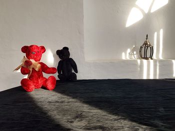 Stuffed toy on table against wall at home