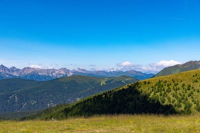 Scenic view of mountains against blue sky