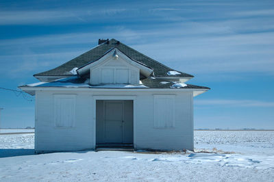 Outbuilding in winter against blue sky