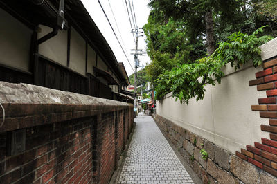 Footpath amidst buildings against sky