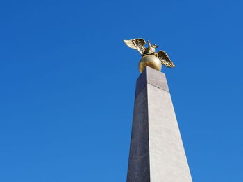 Low angle view of statue against clear blue sky